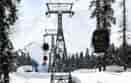 Skiers and tourists ride in a gondola lift, passing over the snow-covered slopes of the famous Gulmarg ski resort in Baramulla district, Jammu and Kashmir, India, on February 12, 2023. The gondola lift offers views of the Himalayan mountains and provides access to higher reaches for winter sports enthusiasts. (Photo by Nasir Kachroo/NurPhoto via Getty Images)