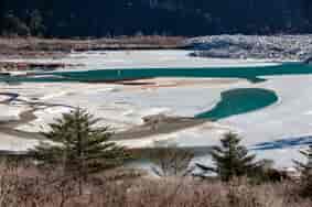 Frozen river with ice and water in sideway that on the way to Zero Point at Lachung in winter. North Sikkim,